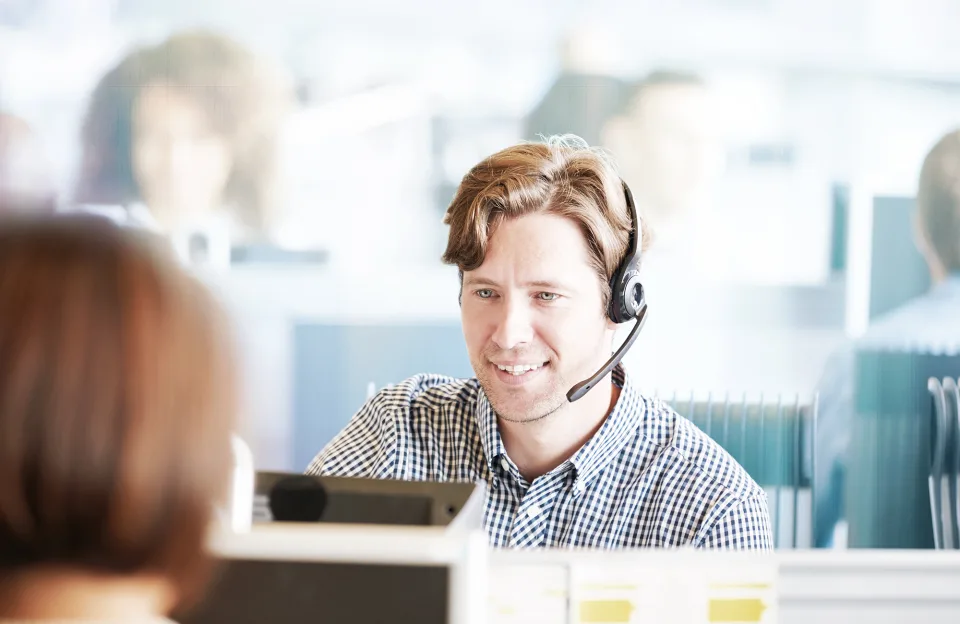 Kontakt Deutsche Glasfaser - Mann telefoniert mit Headset und berät Kunden 