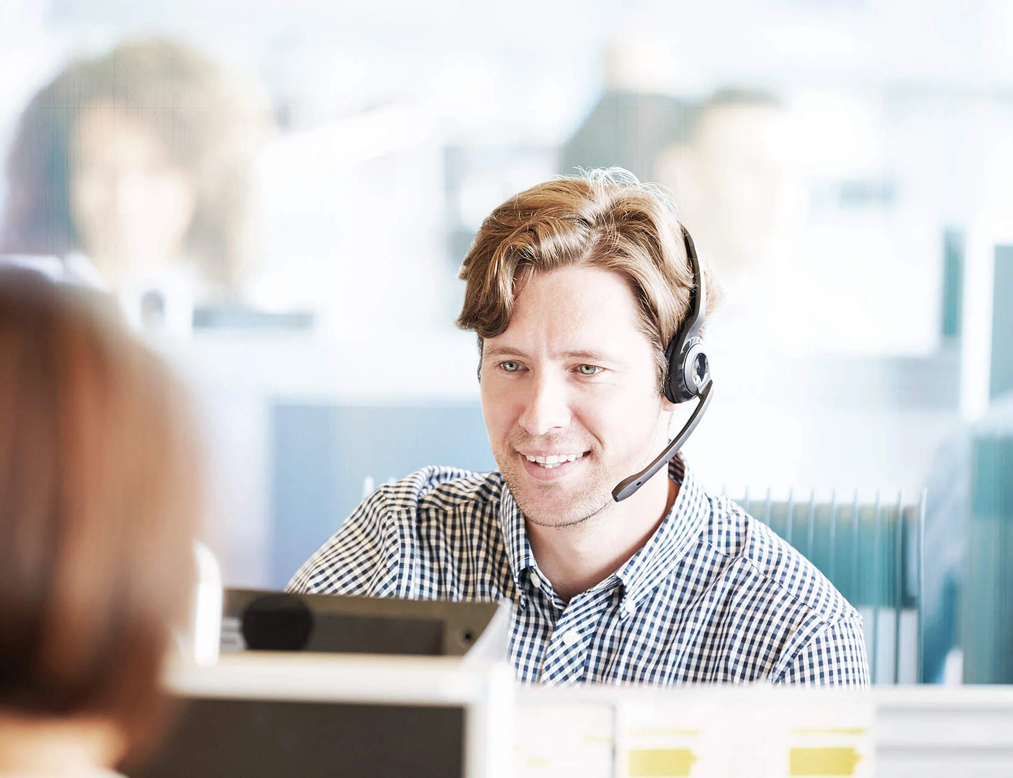 Mann arbeitet und telefoniert über Headset mit Kunden - digitale Beratung