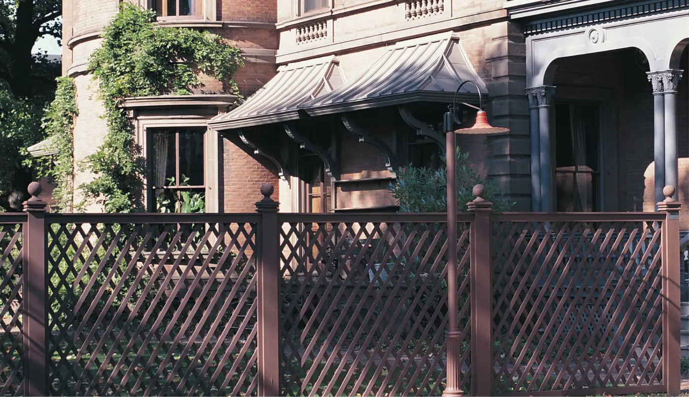 Image of a lattice fence in front of a brick residence