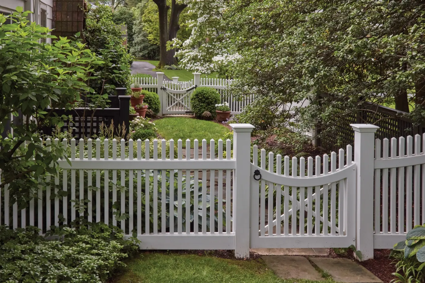 Image of a white fence surrounding the front yard of a residence