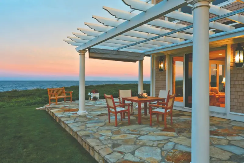 Attached white pergola with seating area on ocean