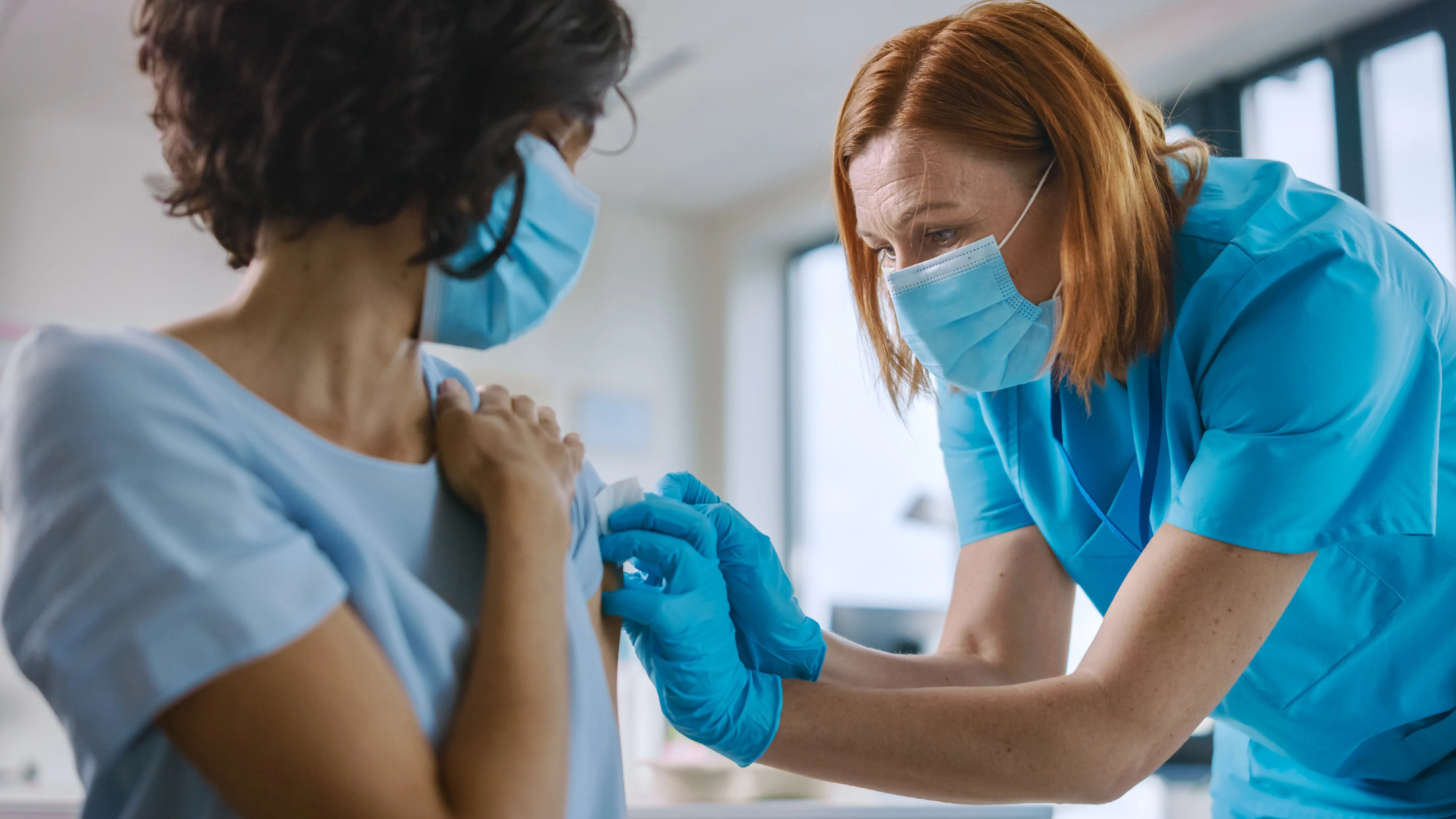 A nurse administers a vaccine to a woman.