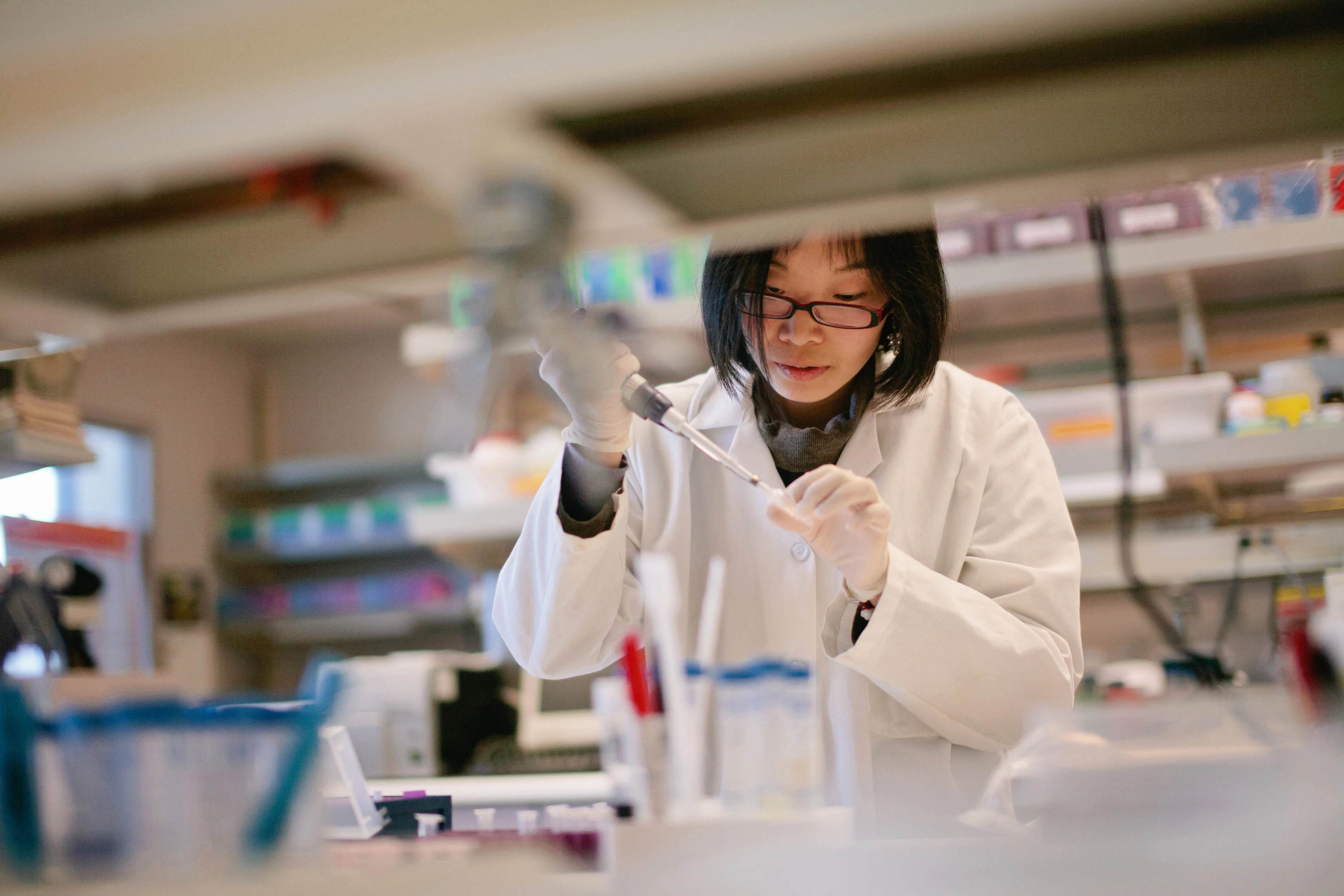 Descriptive image showing a woman in a lab coat working on pharmaceutical production.