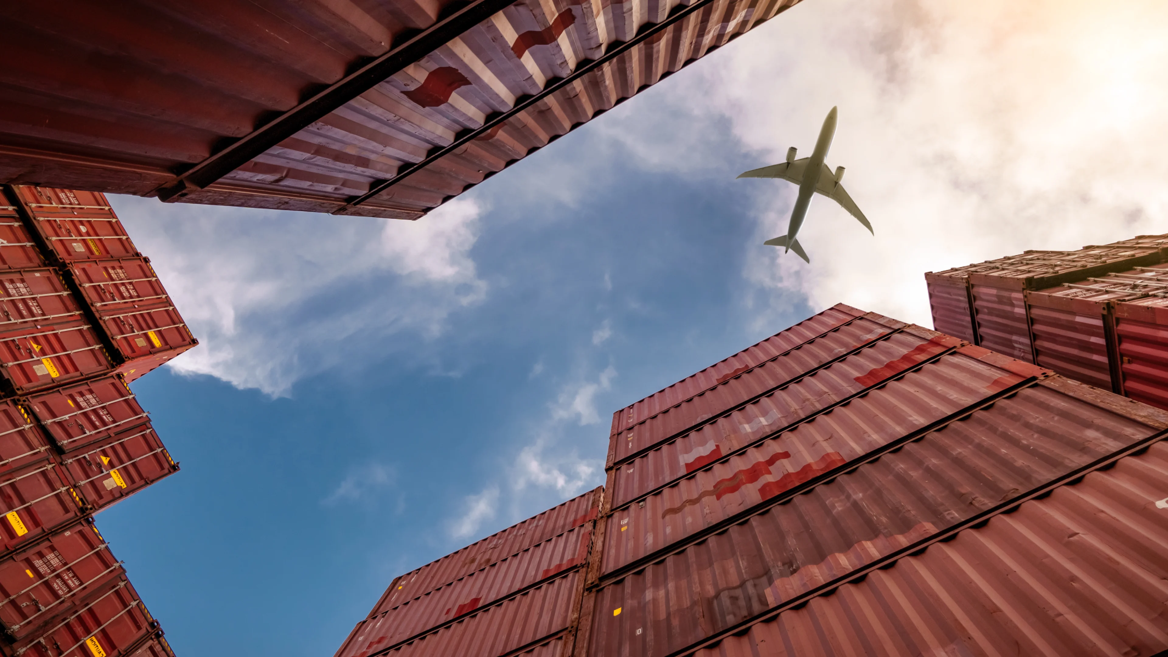 Descriptive image of logistics with an airplane and shipping containers.