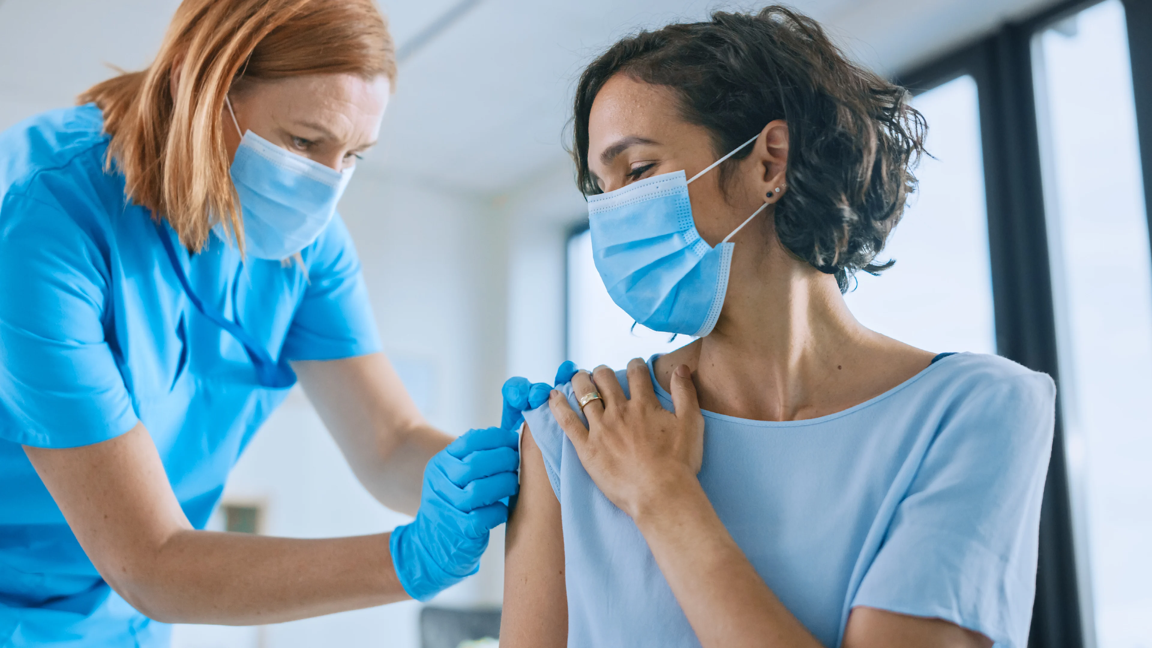 A nurse vaccinating a woman. 