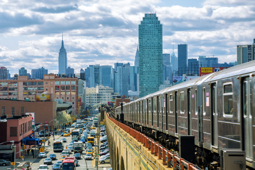 The subway on an elevated track in Queens, with Manhattan in the background.