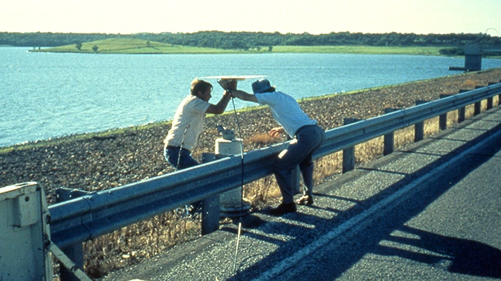 2000: Workers use Spectra Precision on side of road