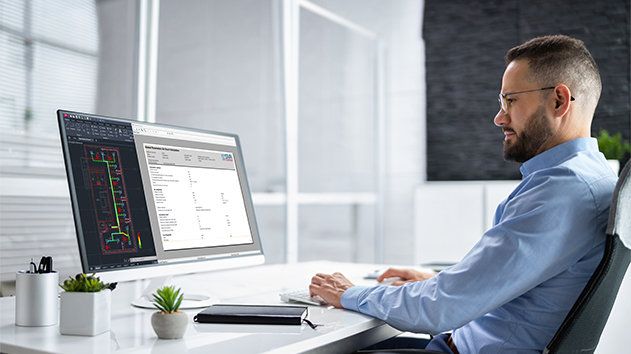 A person using Stabicad for AutoCAD on a large monitor to perform MEP calculations and view a building ductwork layout in an office setting.