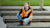 Woman in reflective vest and boots on dock smiling at camera using mobile device