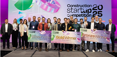 A group of award winners holding large ceremonial checks on stage at the 2025 Construction Startup Competition.