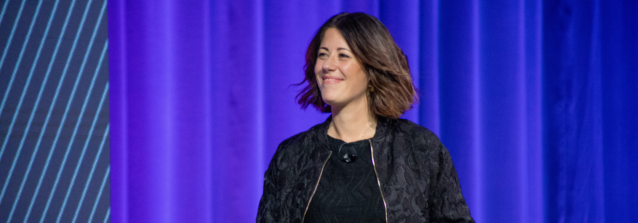 A professional woman presents on stage at a Trimble event with a slide displaying "2D Drawings" and a red "version 1" button in the background.