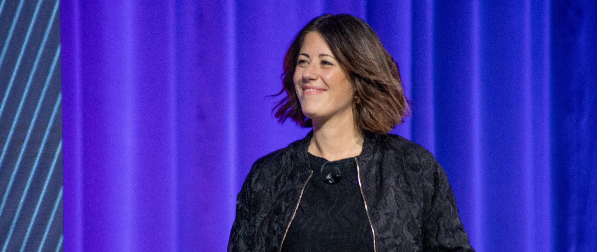 A professional woman presents on stage at a Trimble event with a slide displaying "2D Drawings" and a red "version 1" button in the background.