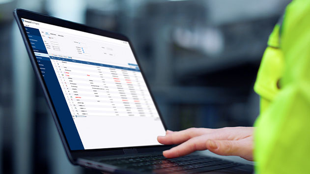 Construction professional using Viewpoint For Projects on a laptop for on-site document management.