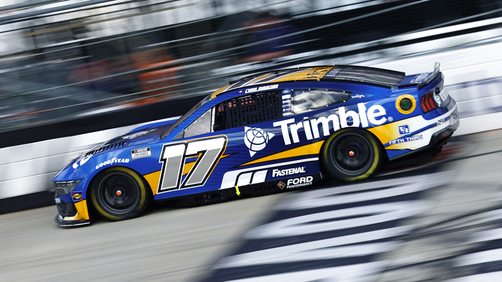 Trimble #17 car driven by Chris Buescher for RFK Racing blurred in motion as it speed around a track.