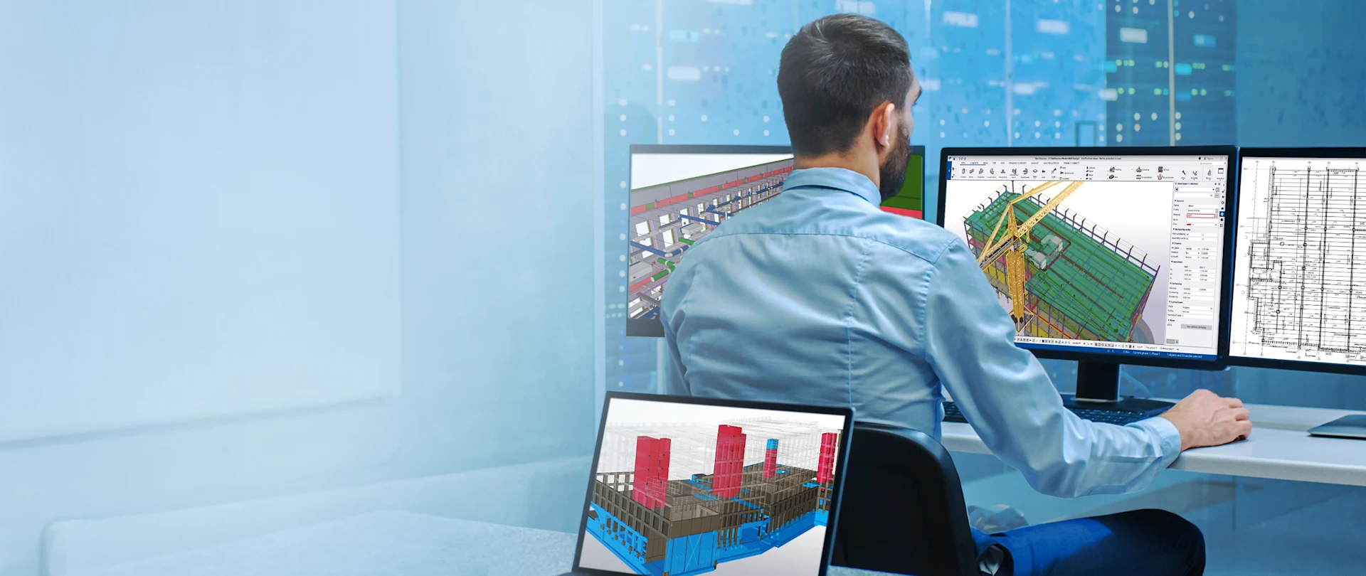 A professional uses Trimble Tekla Structures BIM software on multiple screens for 3D construction modeling and structural design.