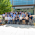 A large group of professionals, some wearing Trimble lanyards and StructShare shirts, pose in front of a modern corporate office building.