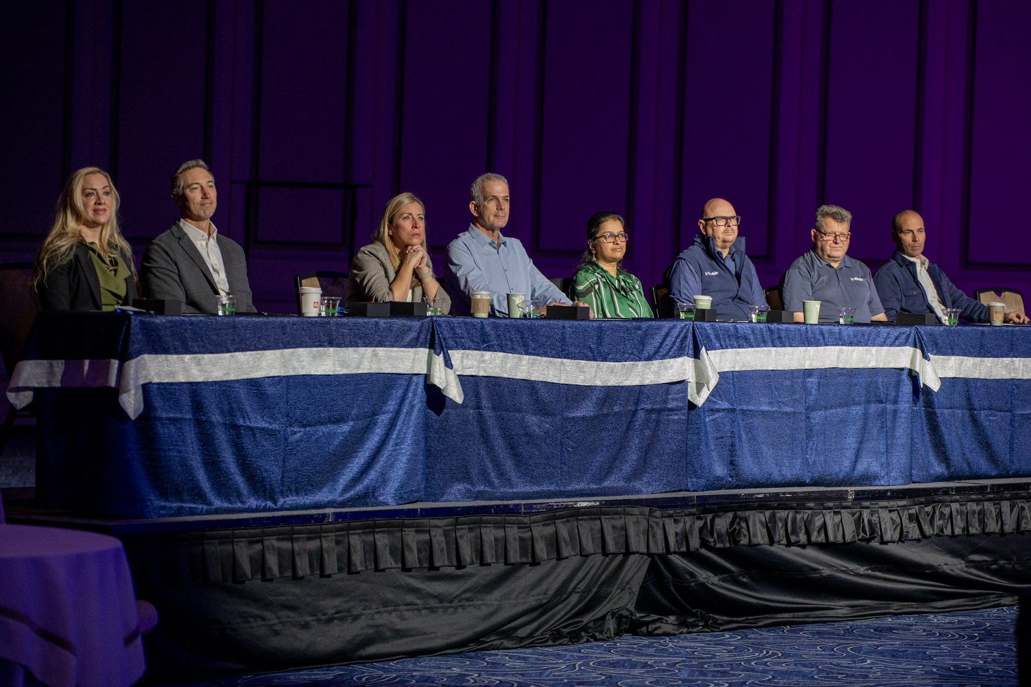 Eight Trimble leaders, including CEO Rob Painter, sit on a stage panel at the Trimble Dimensions conference.