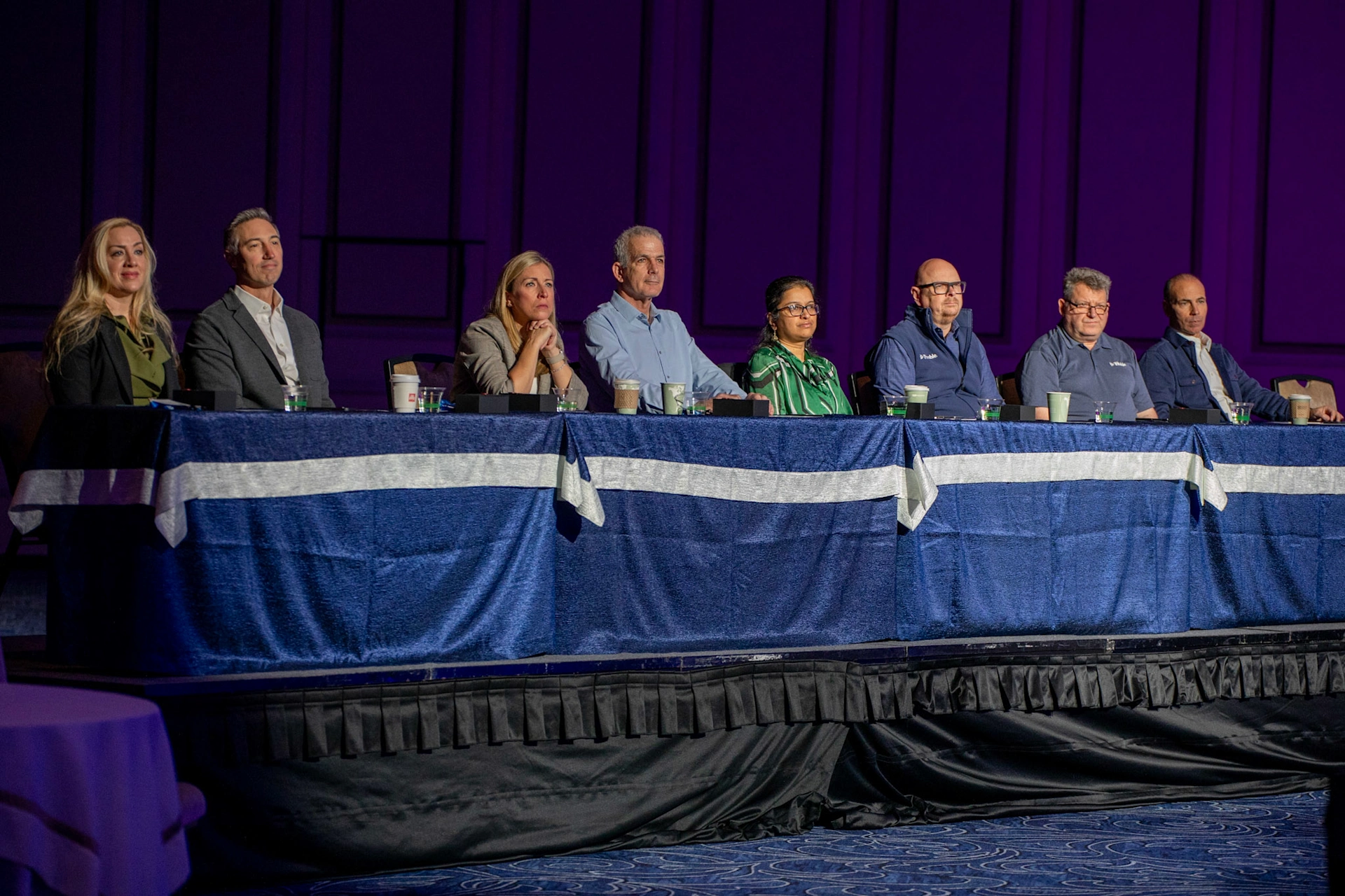 Eight Trimble leaders, including CEO Rob Painter, sit on a stage panel at the Trimble Dimensions conference.
