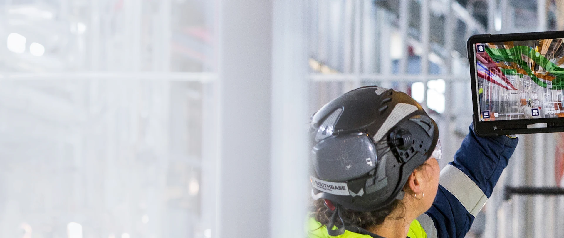 A Southbase Construction worker uses Trimble Connect AR on a tablet to visualize 3D models on a job site.