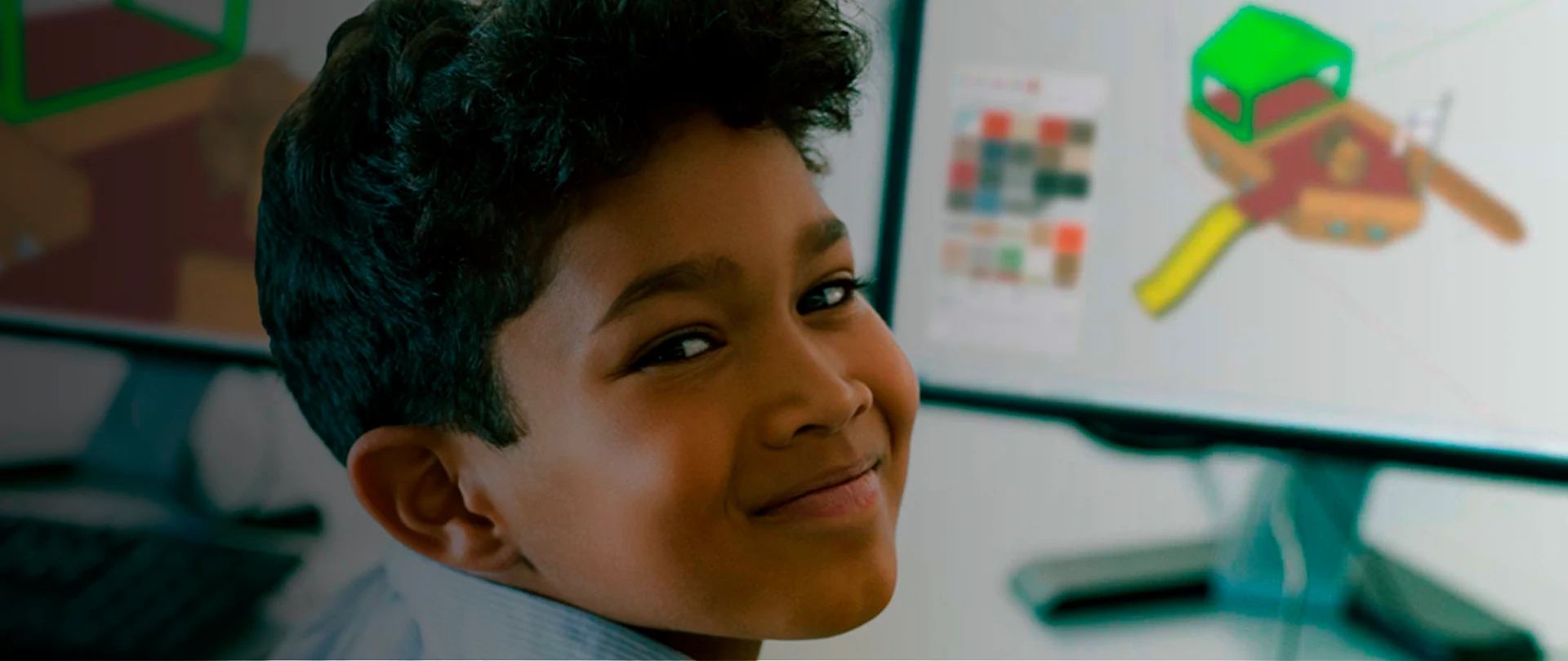 Child smiling at camera using Trimble SketchUp on the computer
