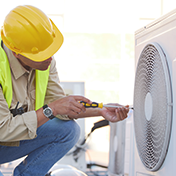 Technician installing wall-mounted air conditioner in a modern interior space