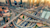 An aerial view of a multi-level highway interchange with traffic surrounded by city skyscrapers.