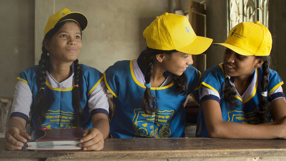 School children in West Bengal, India smiling while sitting at table