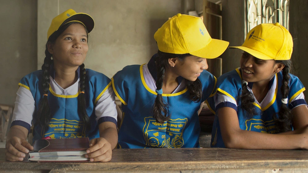 School children in West Bengal, India smiling while sitting at table