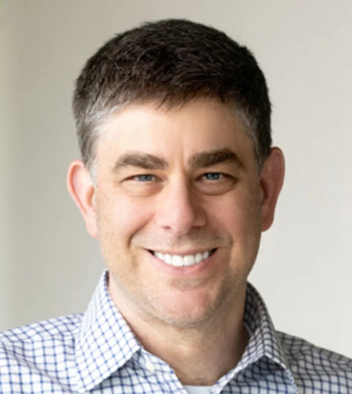 Headshot of Mark Schwartz from Trimble, wearing a blue and white checkered business-casual shirt.