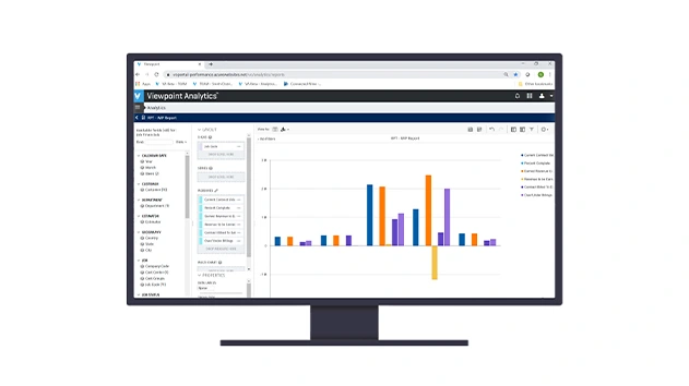 A computer monitor displays the Trimble Viewpoint Analytics interface, featuring a colorful bar chart for construction project data reporting.