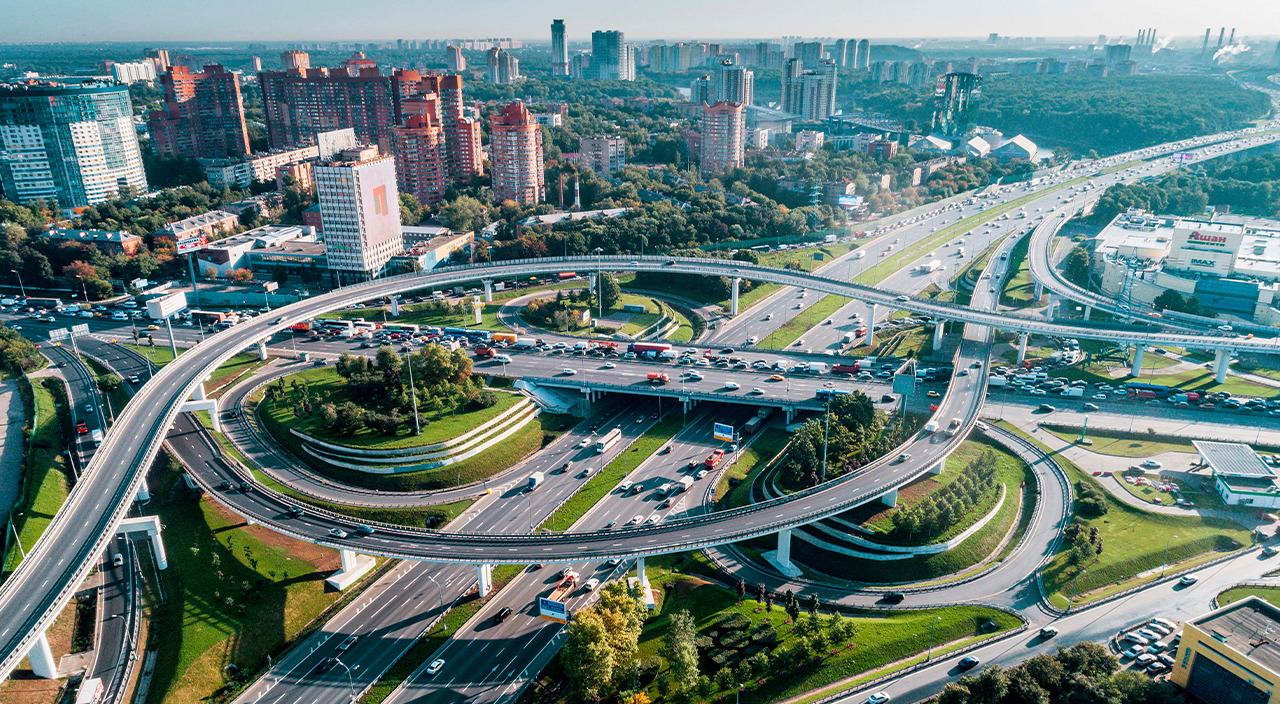 Aerial view of the multi-level Rublevskoye Highway and MKAD interchange in Moscow, featuring the Europark mall and high-rise office buildings.