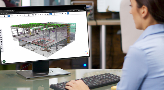 A professional uses the Trimble Connect 3D Viewer on a desktop monitor to analyze a complex 3D construction model.