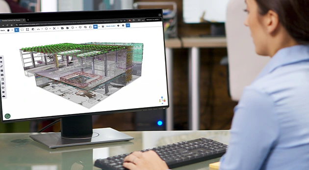 A professional uses the Trimble Connect 3D Viewer on a desktop monitor to analyze a complex 3D construction model.