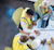 Three AEC professionals in yellow vests review 'BUILDING PROPOSAL' blueprints. An Apple MacBook Pro, white hard hat, and yellow spirit level are on the table.
