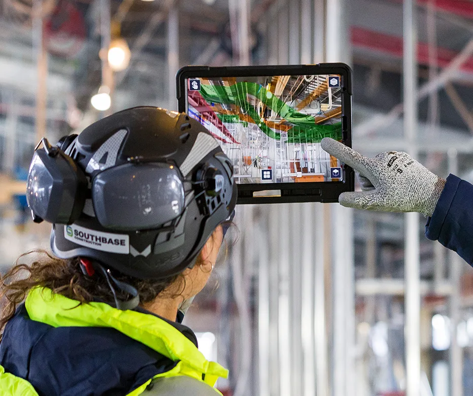 Woman with hard hat using Trimble Connect on a tablet at a job site