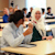 Diverse students sitting in classroom smiling at each other