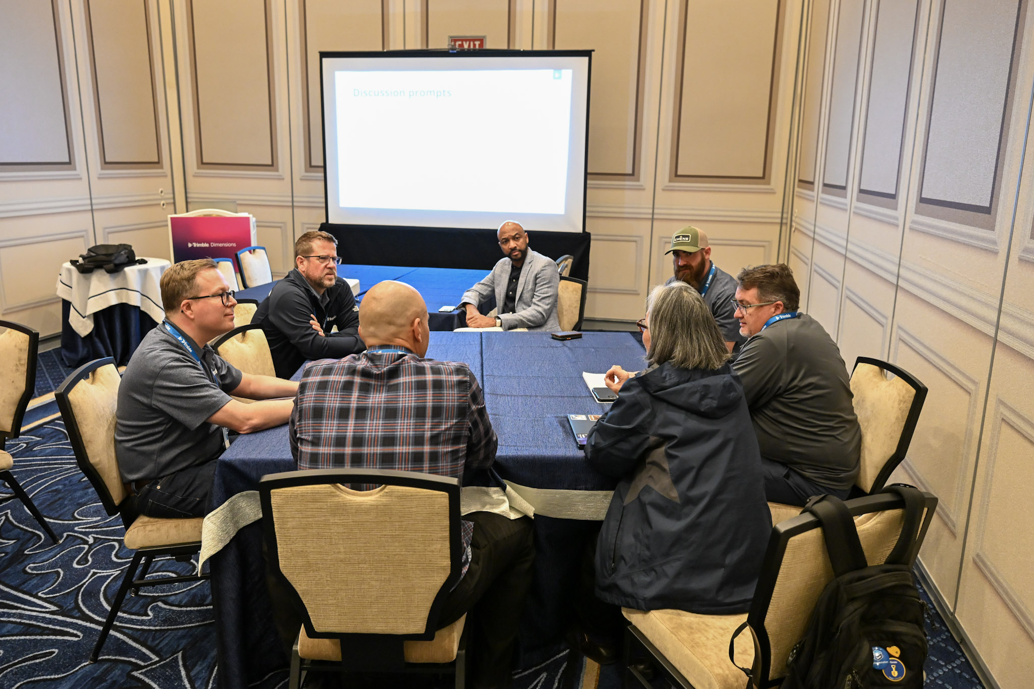 Dimensions attendees are deep in conversation at a round table in a session room.