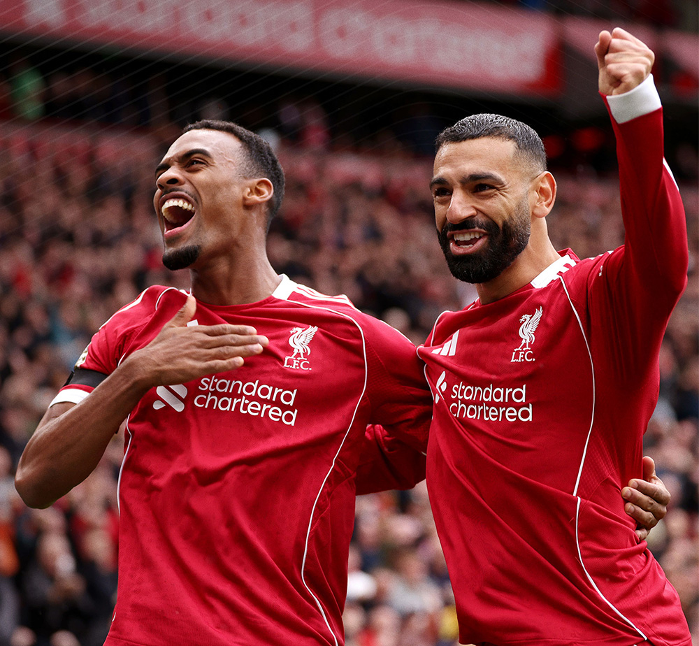 Two players from Liverpool Football Club celebrate during a match