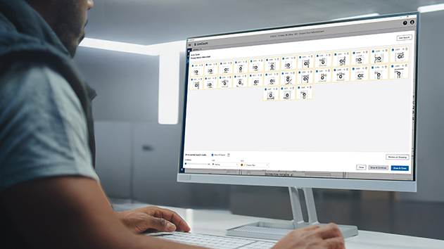 A man works on a computer in a modern office, with the AutoCount search results in LiveCount software displayed on a screen monitor.