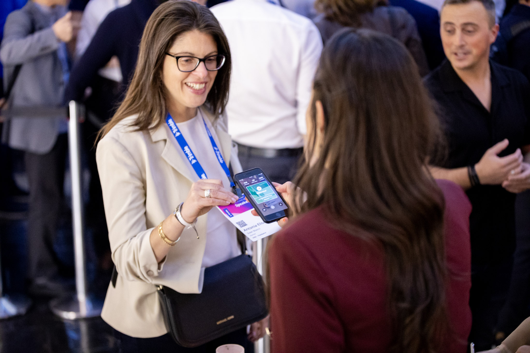 Woman smiles while getting her badge scanned at the entrance of the Trimble Dimensions User Conference at the Venetian in Las Vegas.