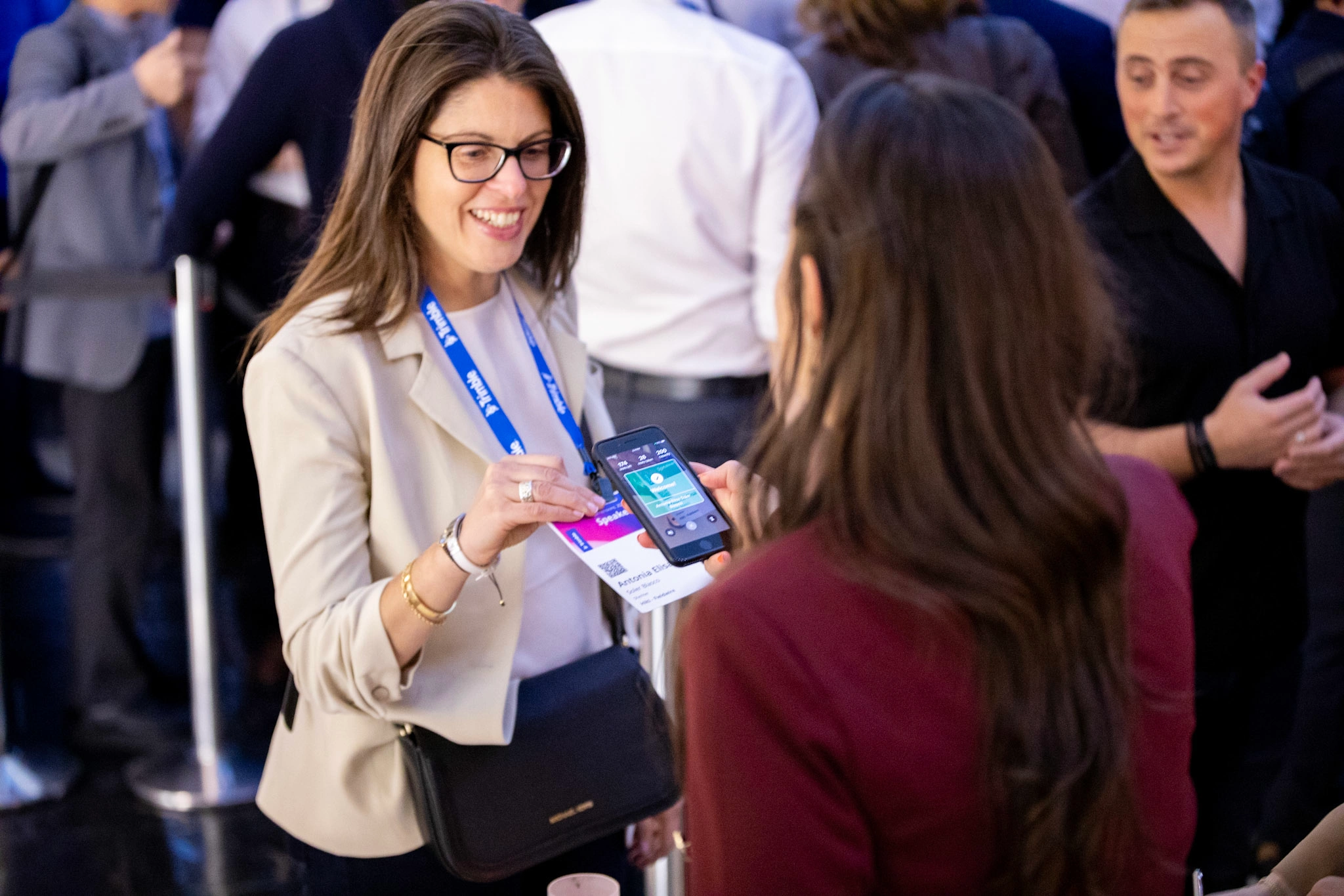 Woman smiles while getting her badge scanned at the entrance of the Trimble Dimensions User Conference at the Venetian in Las Vegas.