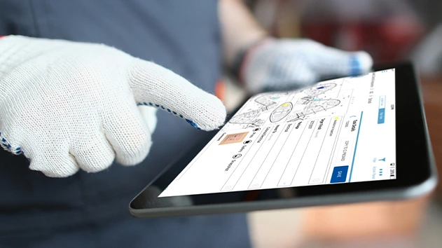 Construction worker in safety gloves using a tablet to capture photos and log task details on a digital site plan.
