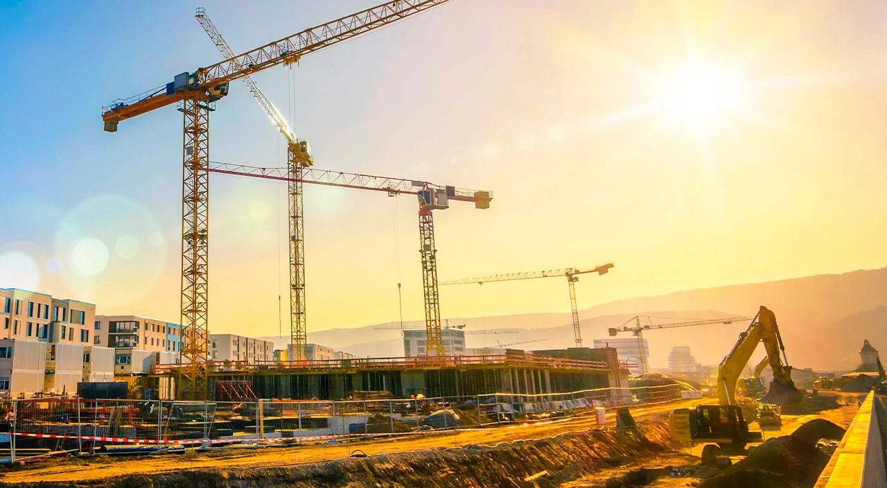 Eine Baustelle mit Kranen und einem Bagger.