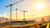 A construction site with multiple cranes and an excavator.
