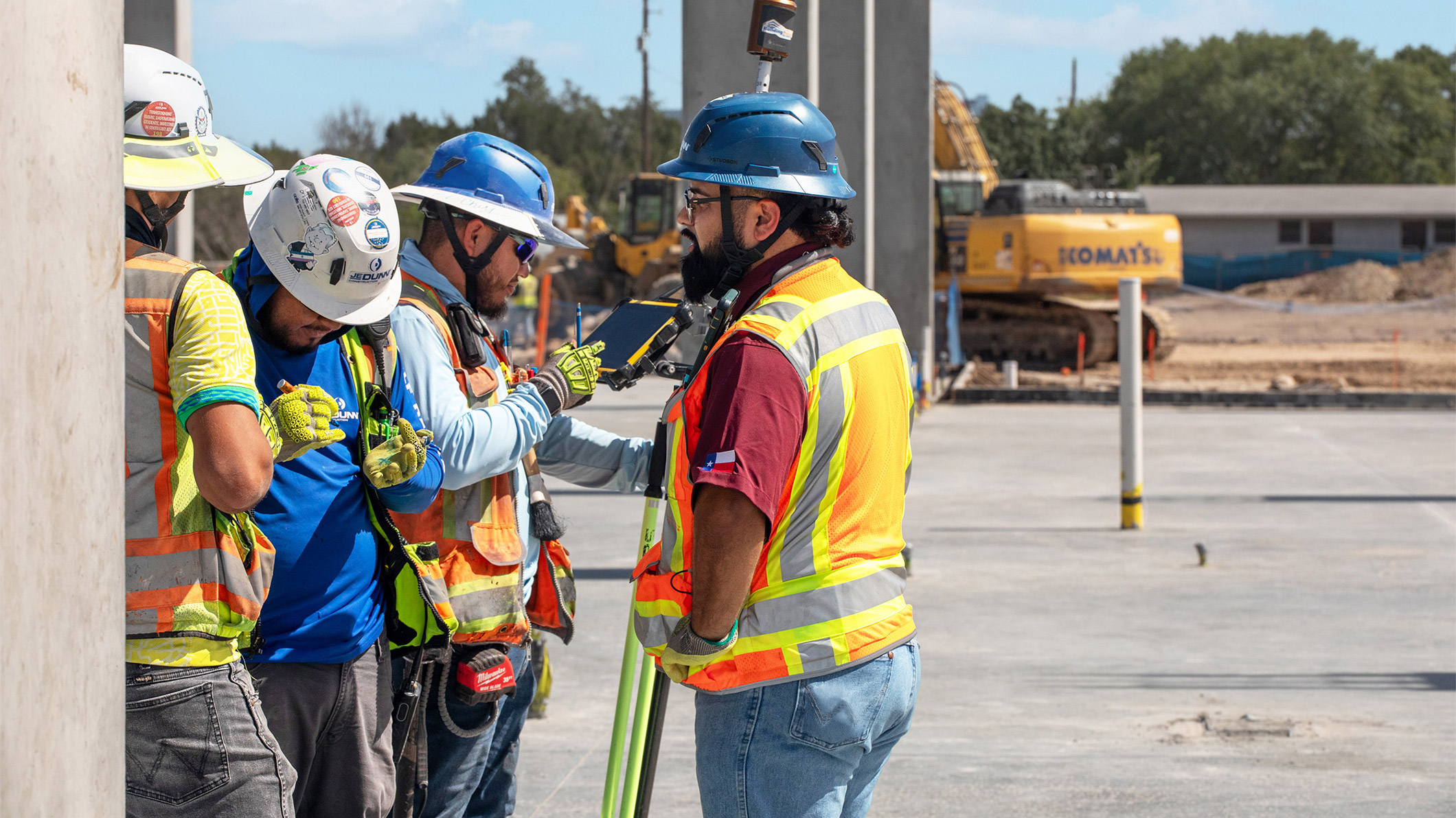 JE Dunn construction team reviewing a digital model on-site, discussing layout and coordination.