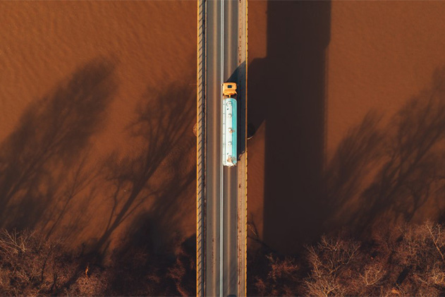 Aerial view of semi-truck on bridge over murky water