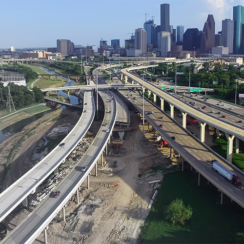 Aerial view of highway construction with city in background