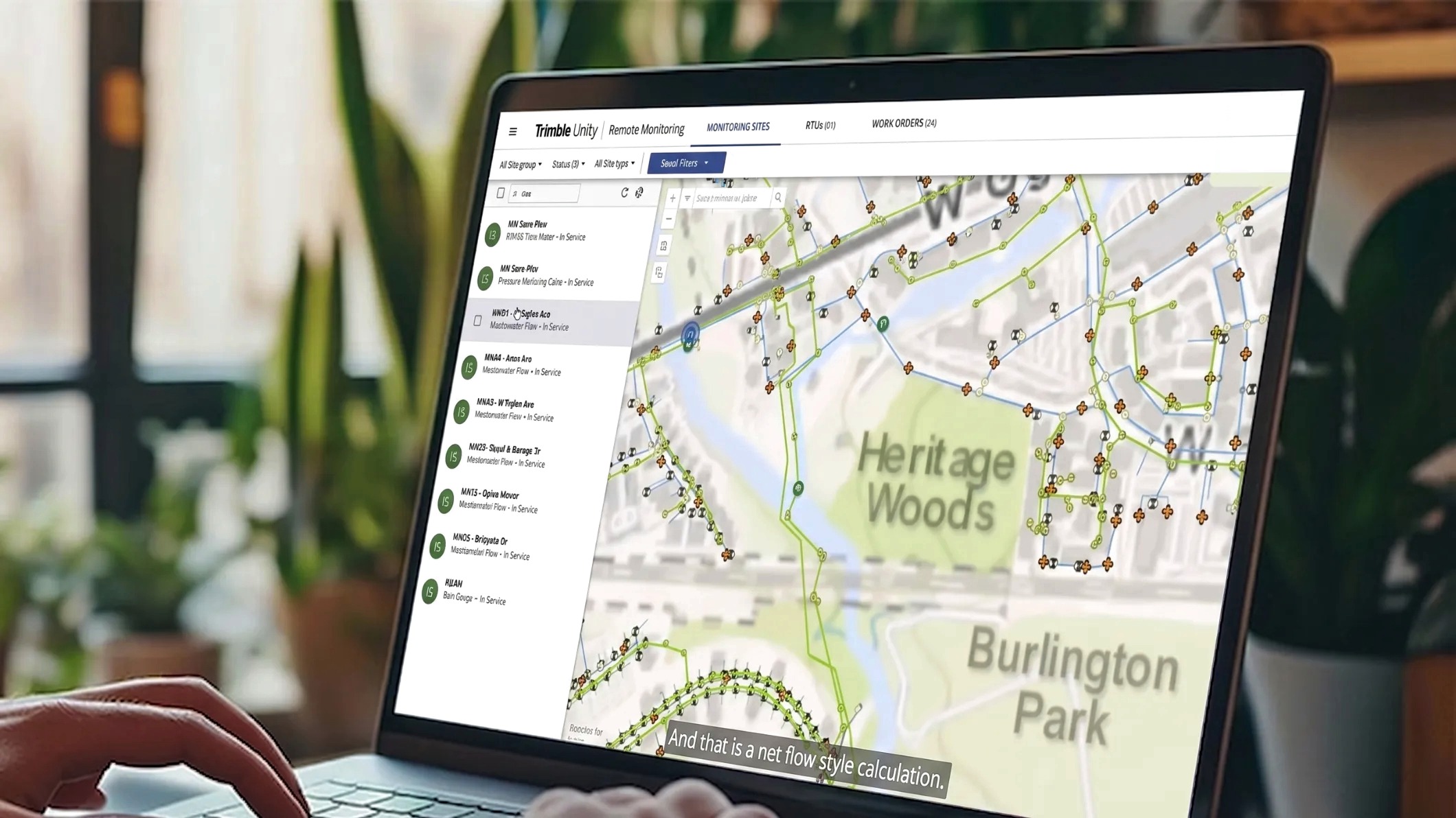Screenshot of Trimble Unity software on a laptop monitor with a office filled with plants as the background.