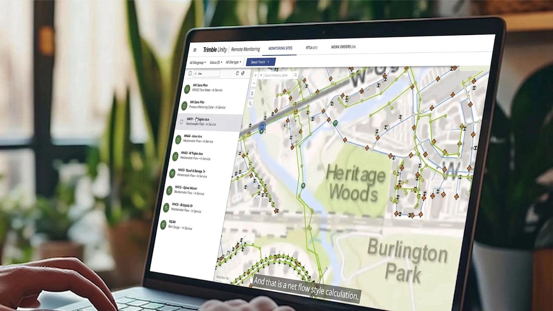 Screenshot of Trimble Unity software on a laptop monitor with a office filled with plants as the background.
