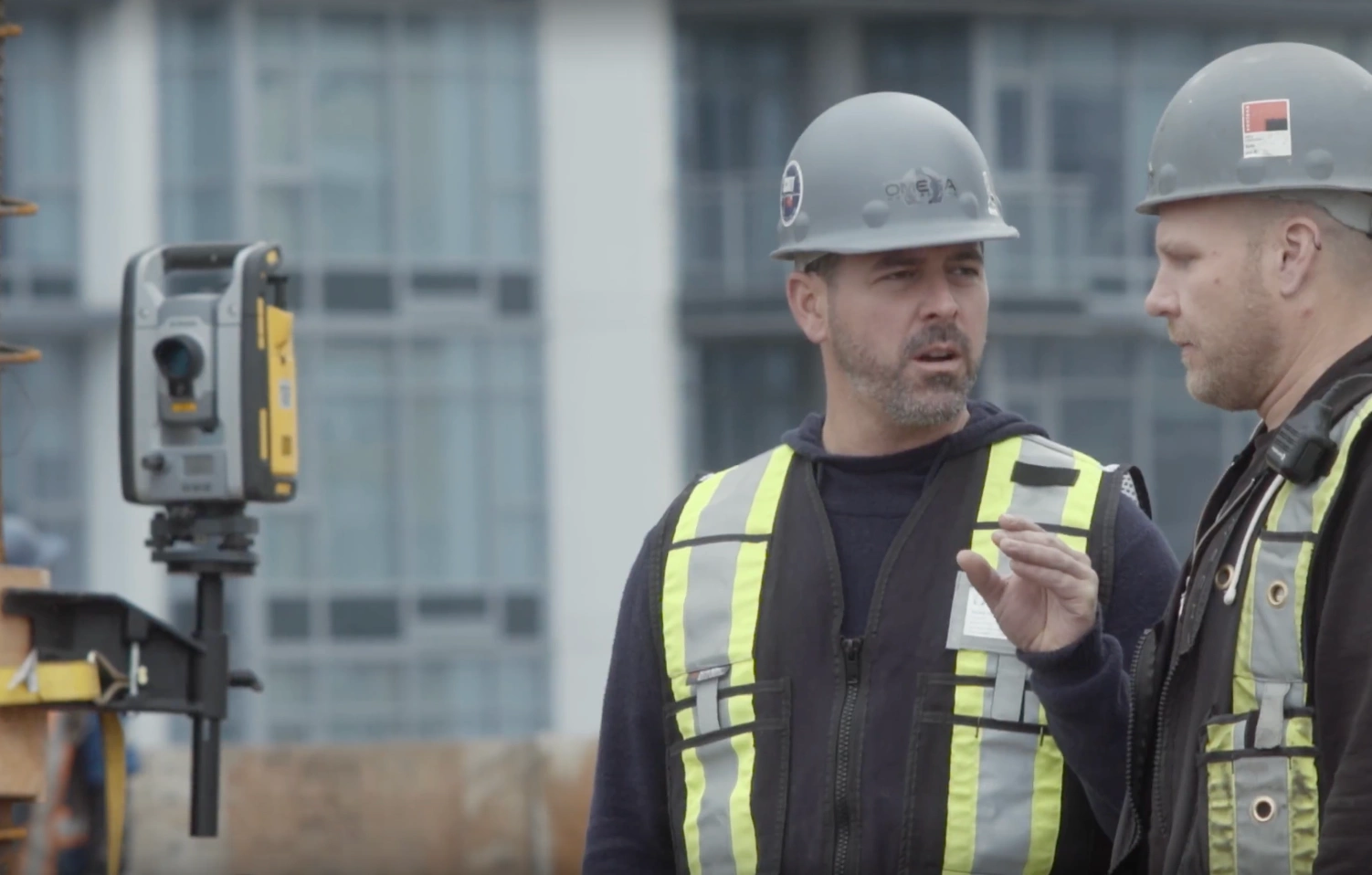 Two construction workers with a robotic total station